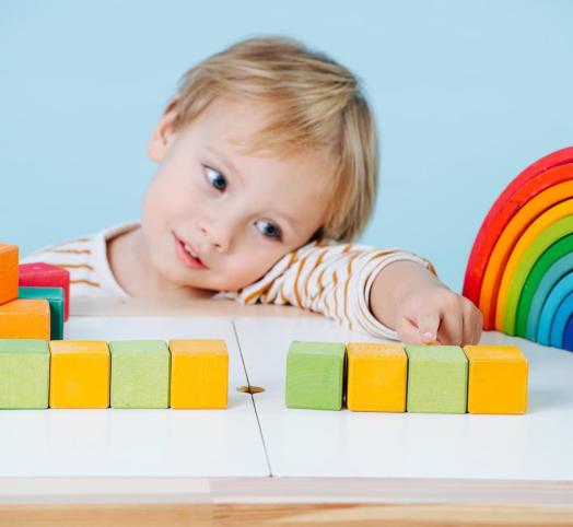 dziecko bawiące się zabawki, by stymulować rozwój mózgu 